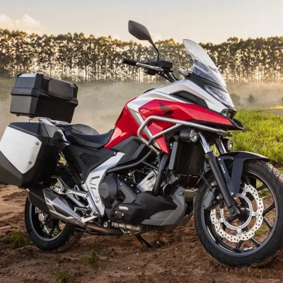 moto-honda-nc-750x-vermelho-grand-prix-red-estacionada-em-paisagem-com-vegetacao-e-chao-de-terra