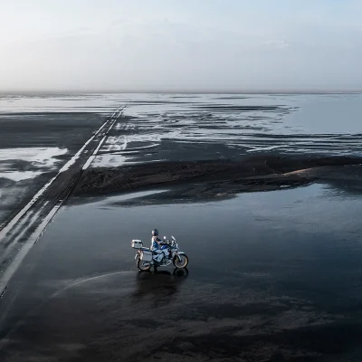 piloto-praia-com-mar-e-areia-molhada-com-sua-moto-honda-crf-1100l-africa-twin-adventure-sports-2023